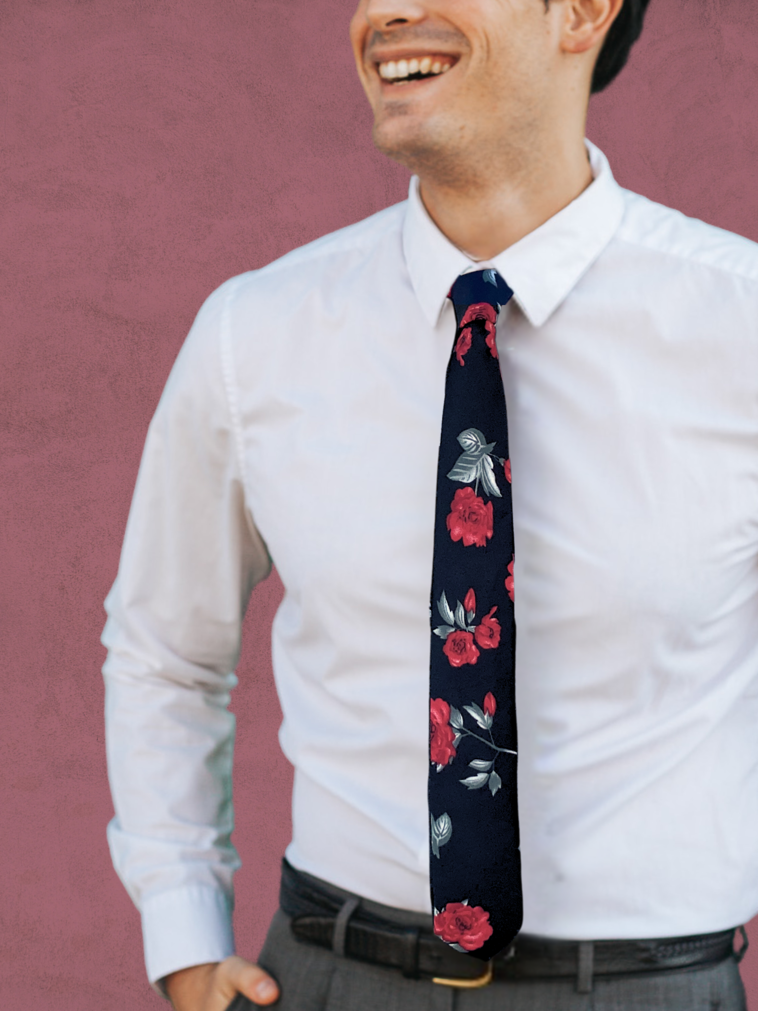 A close up of a man wearing a red, pastel green, and black Christmas floral cotton tie for weddings, grooms, and groomsmen.