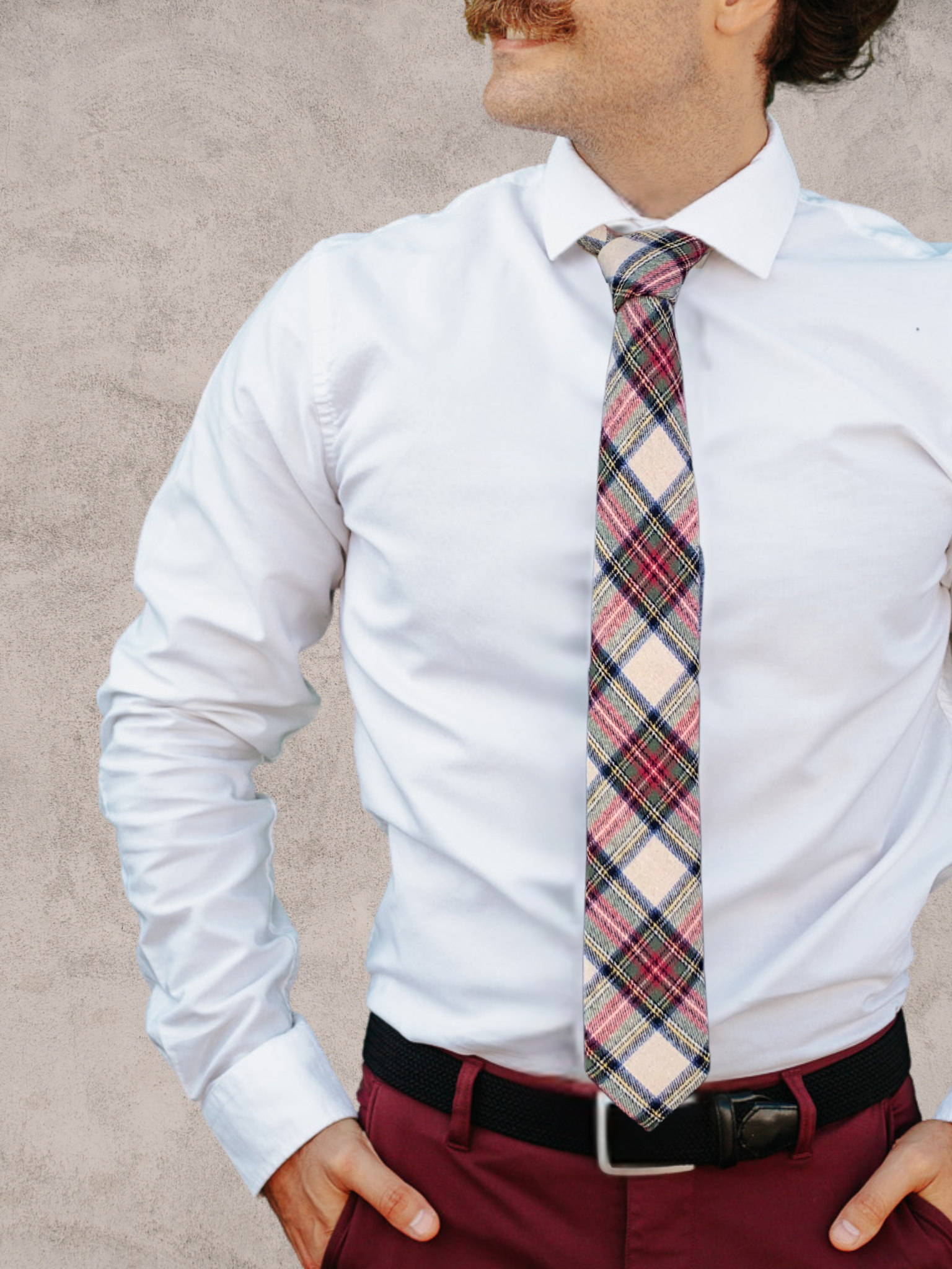 A close up of a man wearing a red, green, blue, and white plaid cotton tie for weddings, grooms, and groomsmen.