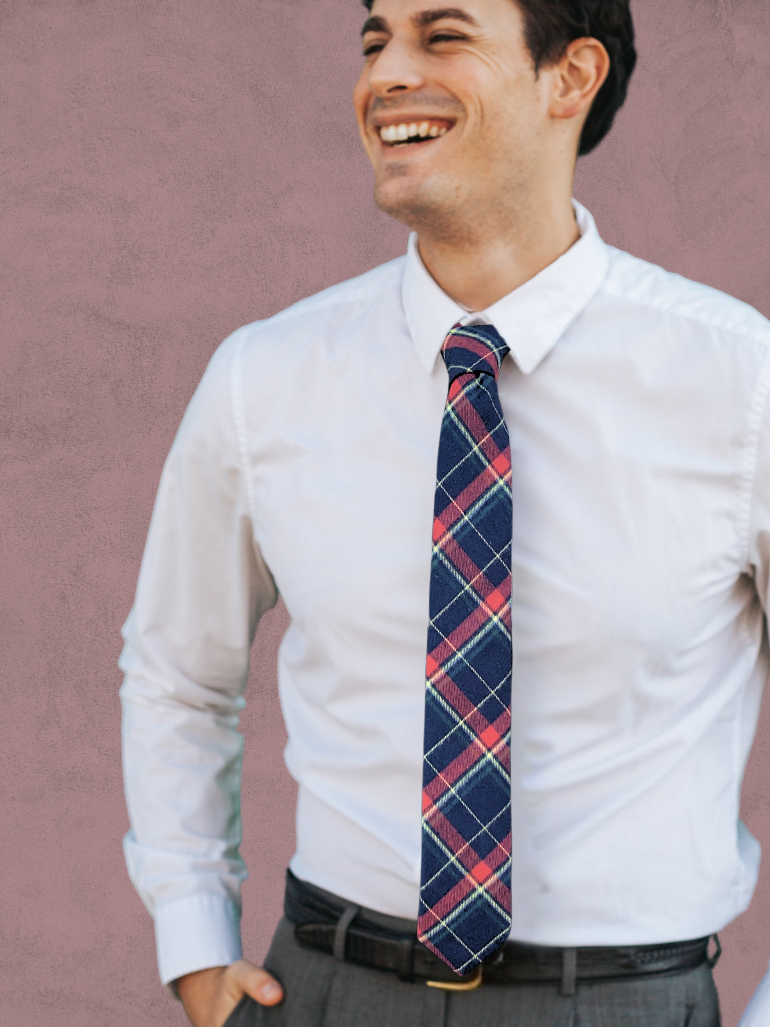 A close up of a man wearing a red, yellow, green, and navy blue plaid cotton tie for weddings, grooms, and groomsmen.