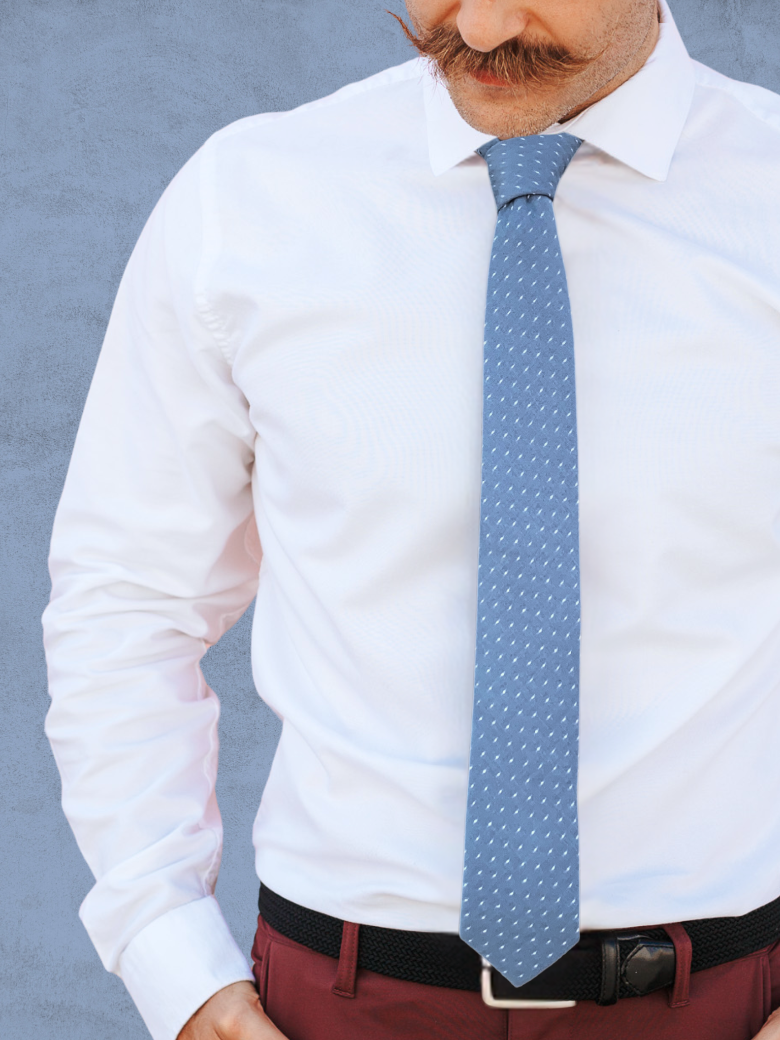 A close up of a man wearing a slate blue gray and white polka dot cotton tie for weddings, grooms, and groomsmen.