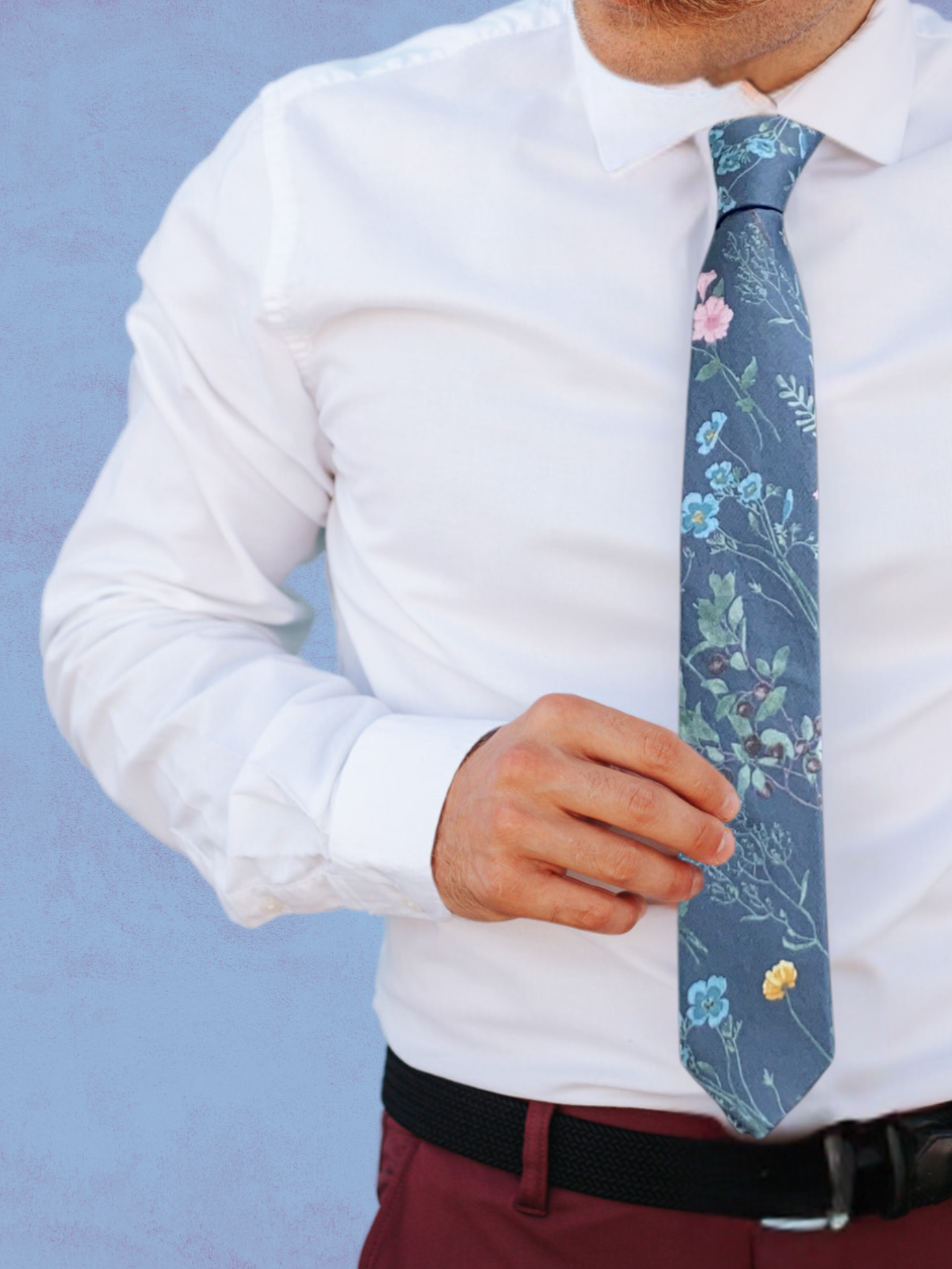 A close up of a man wearing a slate gray, turquoise, pink, and green flower cotton tie for weddings grooms and groomsmen.